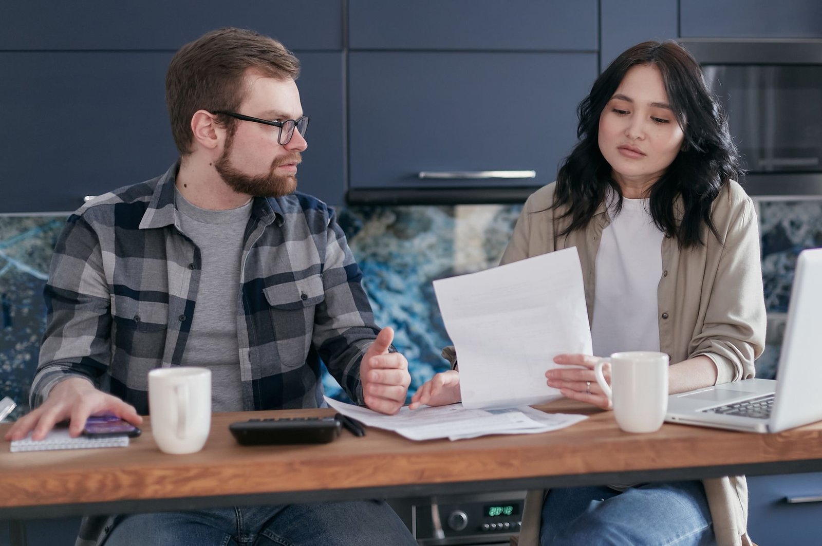 Person using a calculator to work out long term disability benefit offsets on a kitchen table