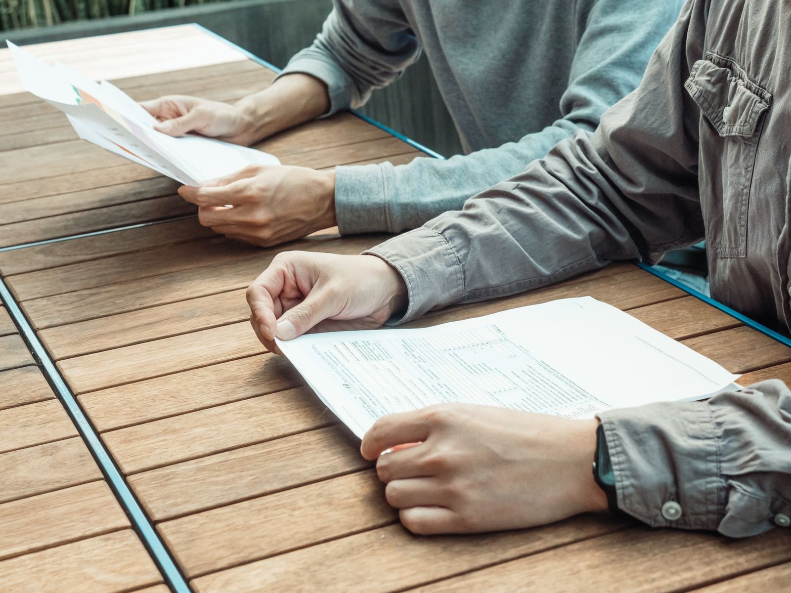 Two people reviewing a long term disability claim file and policy documents at a table