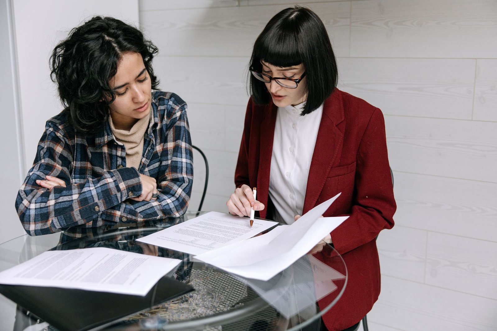 Two people reviewing claim documents at an office table before an independent medical exam for a disability claim