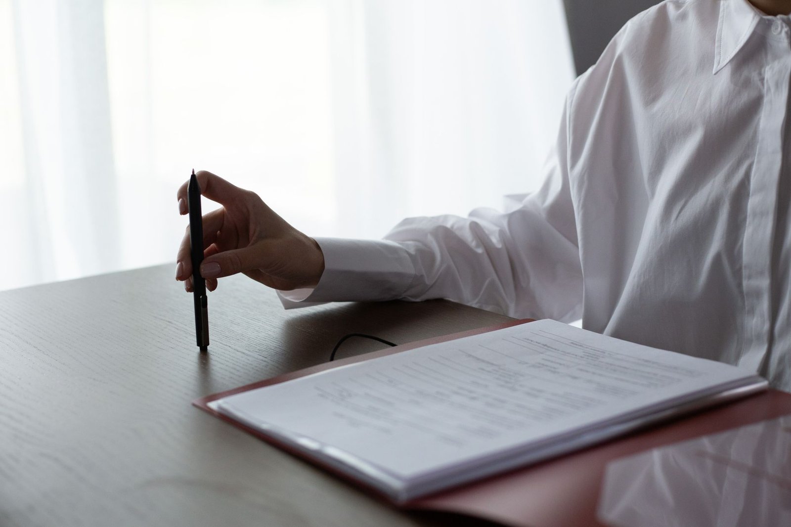 Person at a desk reviewing claim paperwork after receiving a disability claim surveillance report